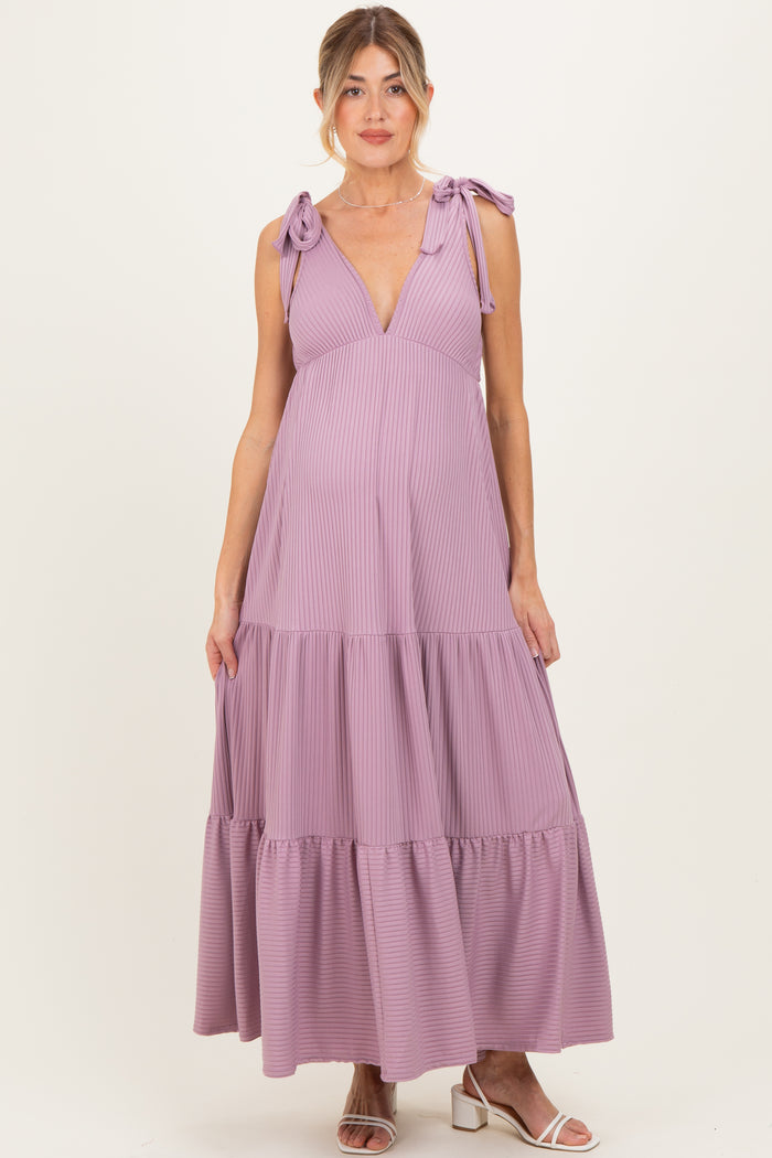 woman wearing a lilac maternity dress with adjustable tie straps and tiered skirt, showing her baby bump