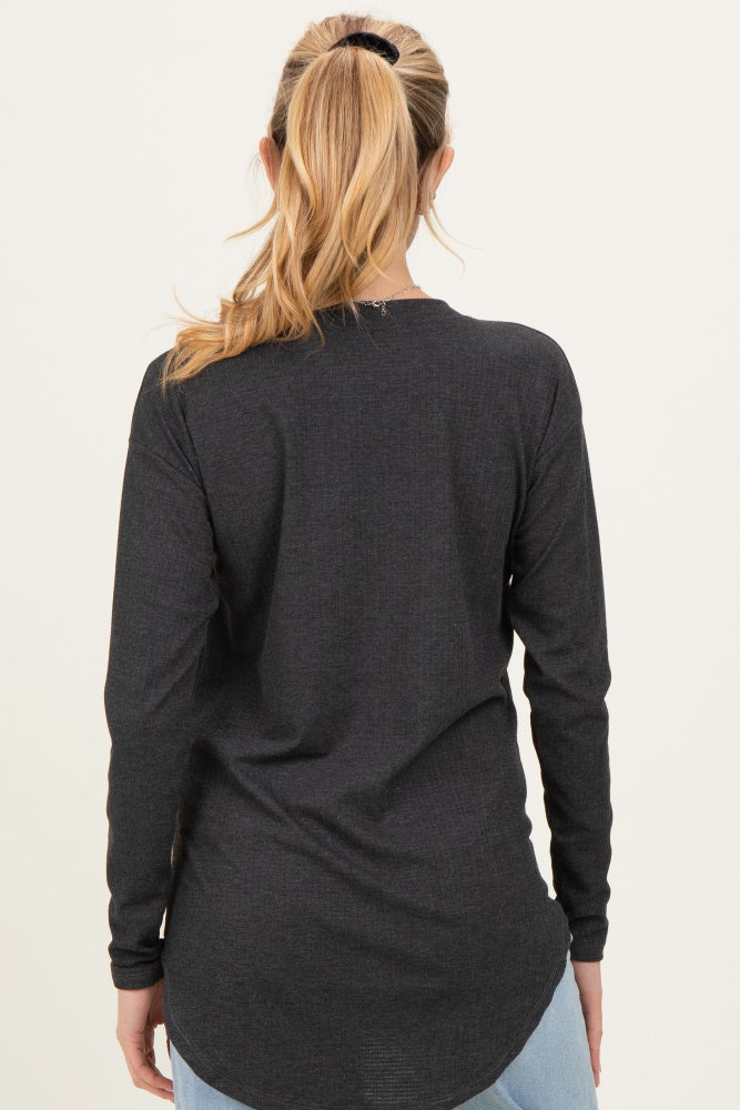 woman wearing a dark gray long sleeve maternity top with a curved hem, viewed from the back