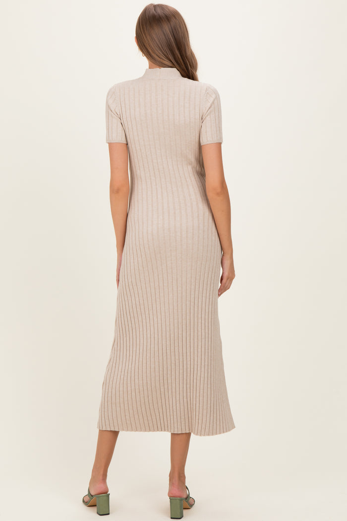 woman wearing a beige ribbed midi maternity dress with a fitted silhouette and short sleeves