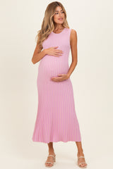 woman wearing a pink ribbed maternity dress and holding her baby bump