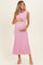 woman wearing a pink ribbed maternity dress and holding her baby bump