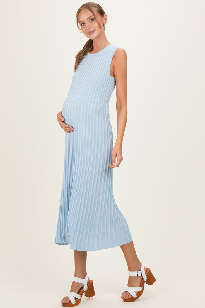 woman wearing a light blue ribbed maternity dress and showing her baby bump