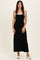woman wearing a black maxi dress with white straps and white sandals