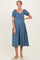woman wearing a blue denim maternity dress with short ruffled sleeves and a relaxed fit, showcasing her baby bump