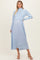 woman wearing a light blue maternity dress with a ribbed sweater top and flowy skirt, showcasing her baby bump