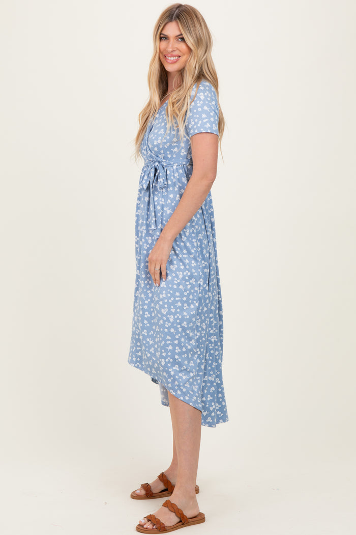 woman wearing a light blue floral print midi dress with a tied waist and short sleeves