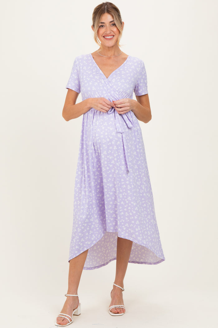 woman wearing a lavender floral maternity dress with a wrap tie and a high-low hem, showing her baby bump