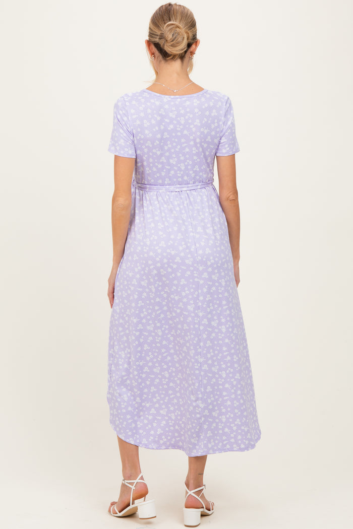woman wearing a lavender floral maternity maxi dress with short sleeves and a cinched waist, showing her baby bump