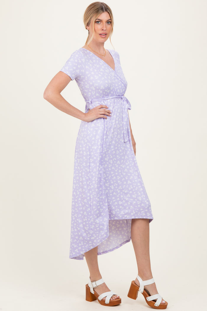 woman wearing a lavender wrap dress with floral print and short sleeves, styled with a tied waist and asymmetrical hem