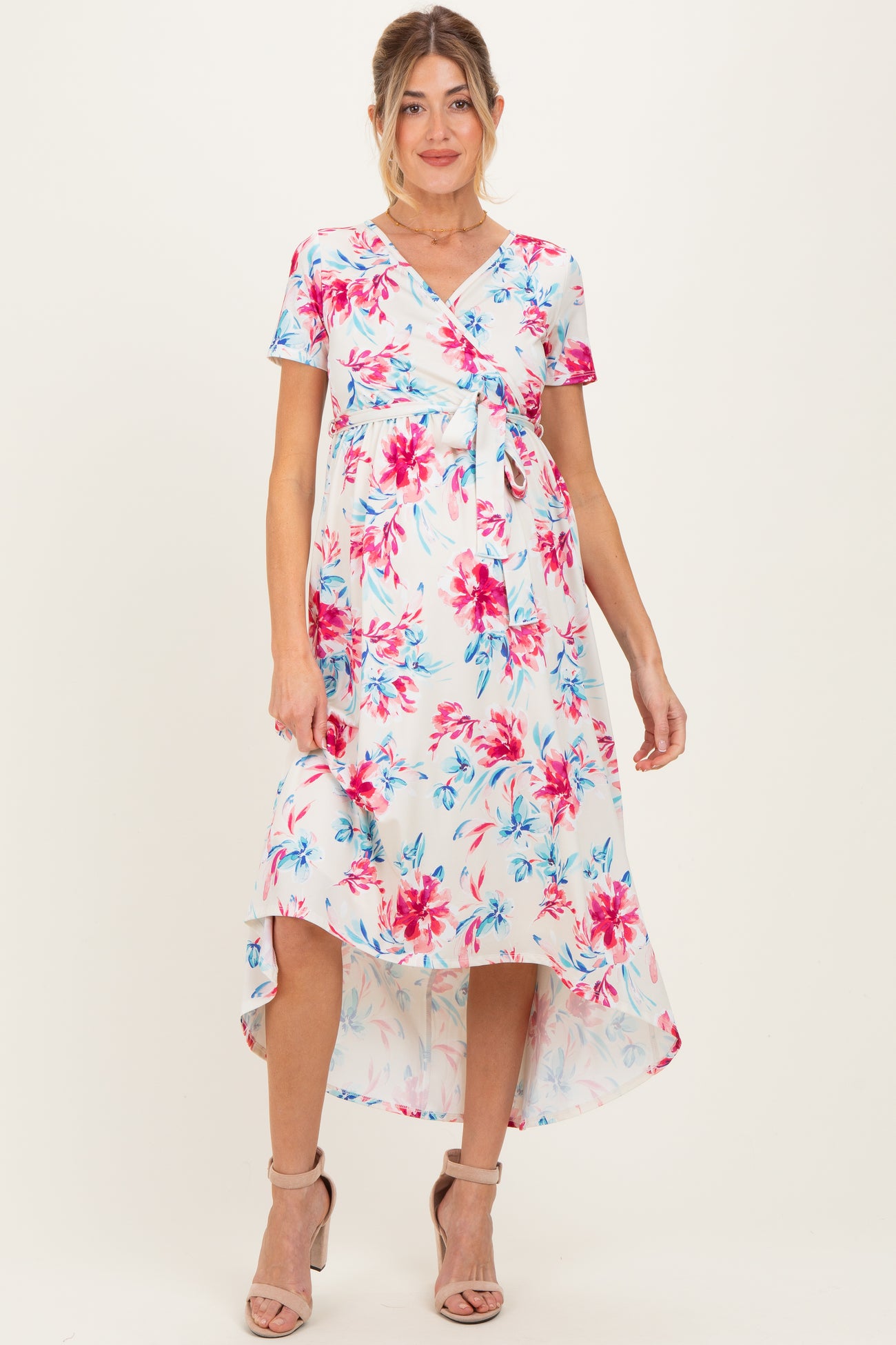 woman wearing a floral maternity dress with a tie waist and high-low hem, showcasing her baby bump