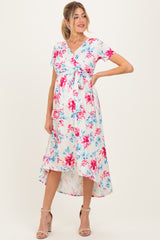 woman wearing a floral maternity dress with short sleeves and a tie front, showcasing her baby bump