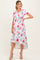 woman wearing a floral maternity dress with short sleeves and a tie front, showcasing her baby bump