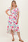 woman wearing a floral print wrap dress with short sleeves and a high-low hemline, styled with strappy sandals