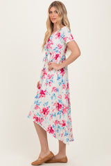 woman wearing a white floral print midi dress with short sleeves and a tie waist, paired with tan shoes