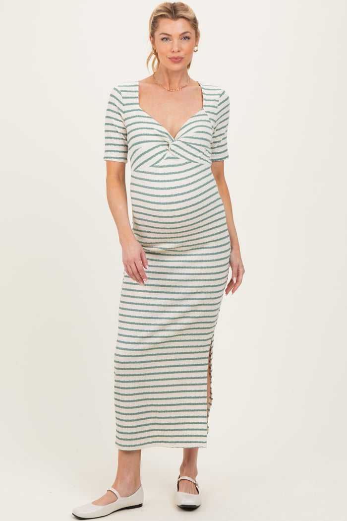 woman wearing a striped maternity maxi dress with short sleeves and a twist front detail, showcasing her baby bump