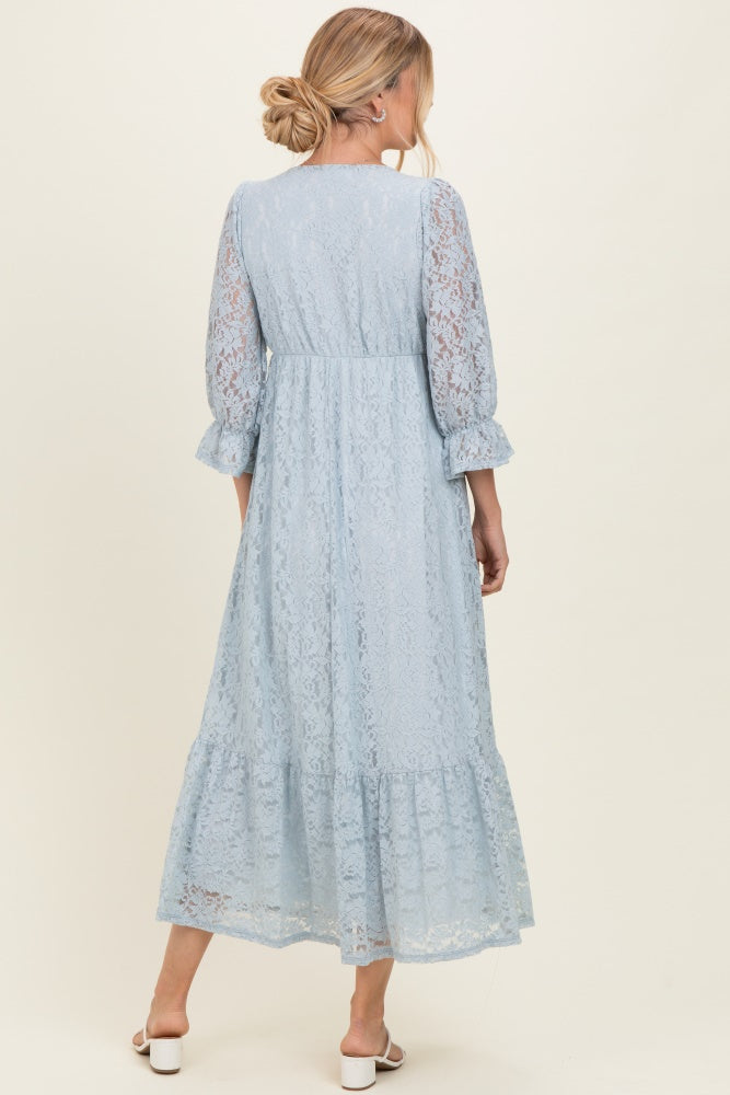 woman wearing a light blue lace maxi dress with three-quarter sleeves and a tiered hem, shown from the back