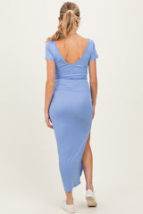 woman wearing a light blue maternity maxi dress with a deep v-back and side slit