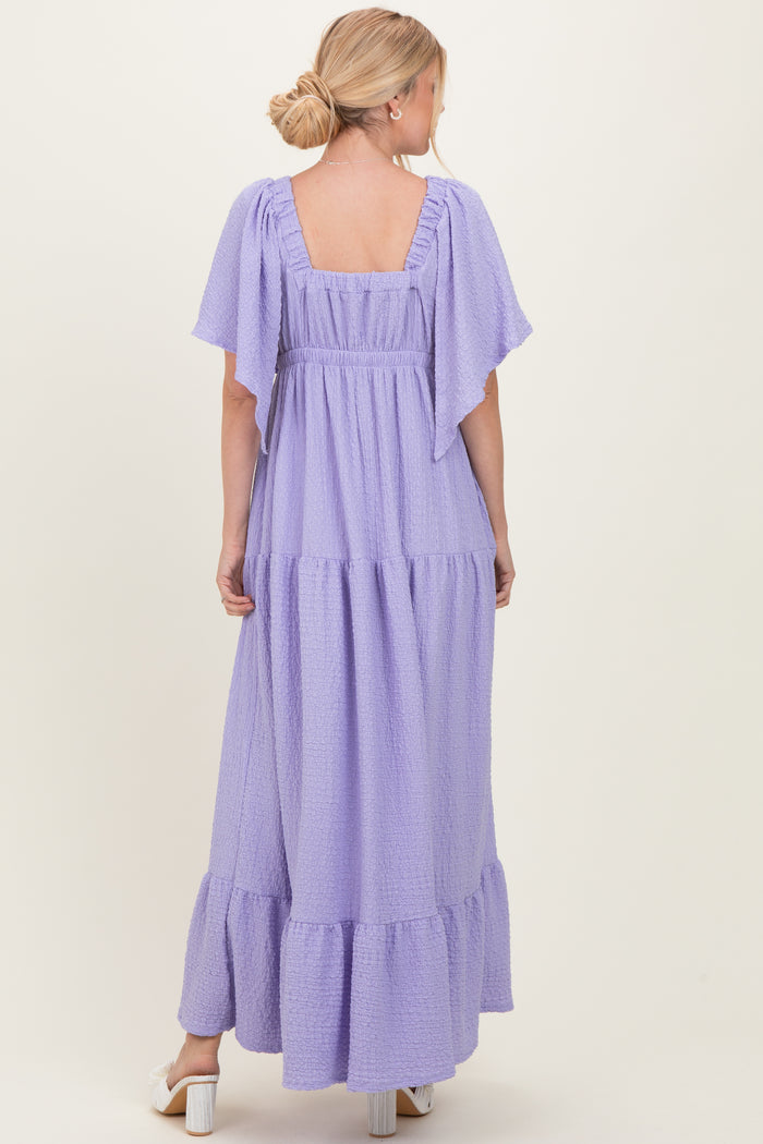 woman wearing a lavender maxi dress with flutter sleeves and tiered ruffle hem, seen from the back