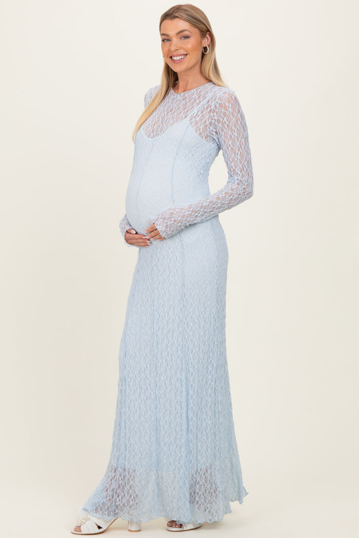 woman wearing a light blue lace maternity gown with long sleeves and a visible baby bump
