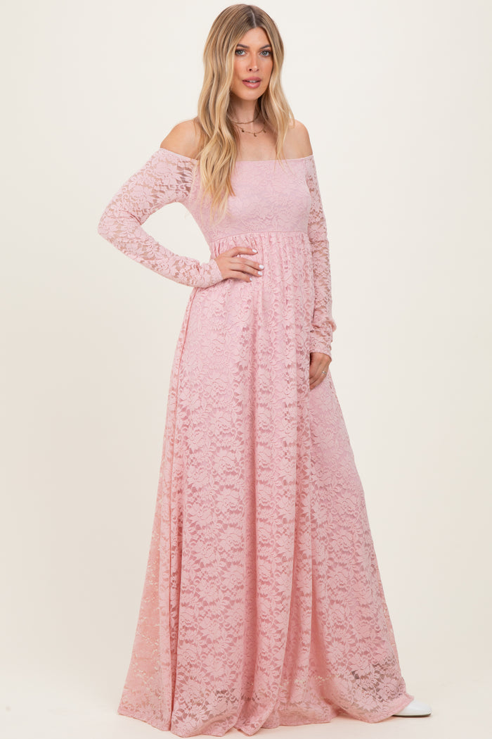 woman wearing a long pink lace off-shoulder maxi dress with long sleeves and a fitted bodice