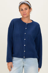 woman wearing a navy blue button-up cardigan with long sleeves and relaxed fit, styled with a headband and light jeans