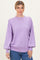 woman wearing a light purple oversized sweater with balloon sleeves and a crew neckline paired with blue jeans