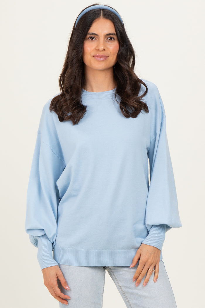 woman wearing a light blue oversized sweater with balloon sleeves and a matching headband