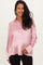 woman wearing a light pink satin maternity shirt, showing her baby bump with a smiling expression