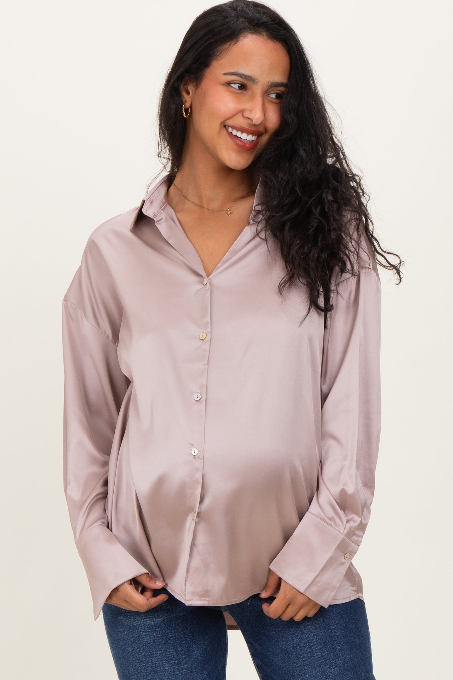 woman wearing a rose satin maternity shirt with a relaxed fit and visible baby bump