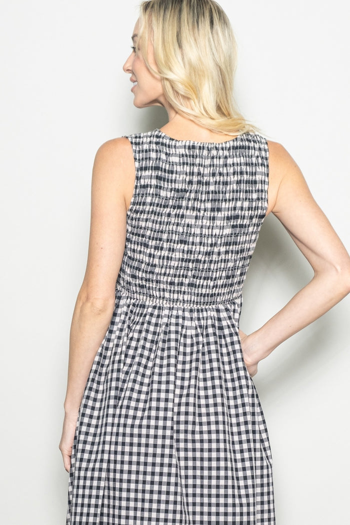 woman wearing a black and white gingham dress with a smocked back and sleeveless design