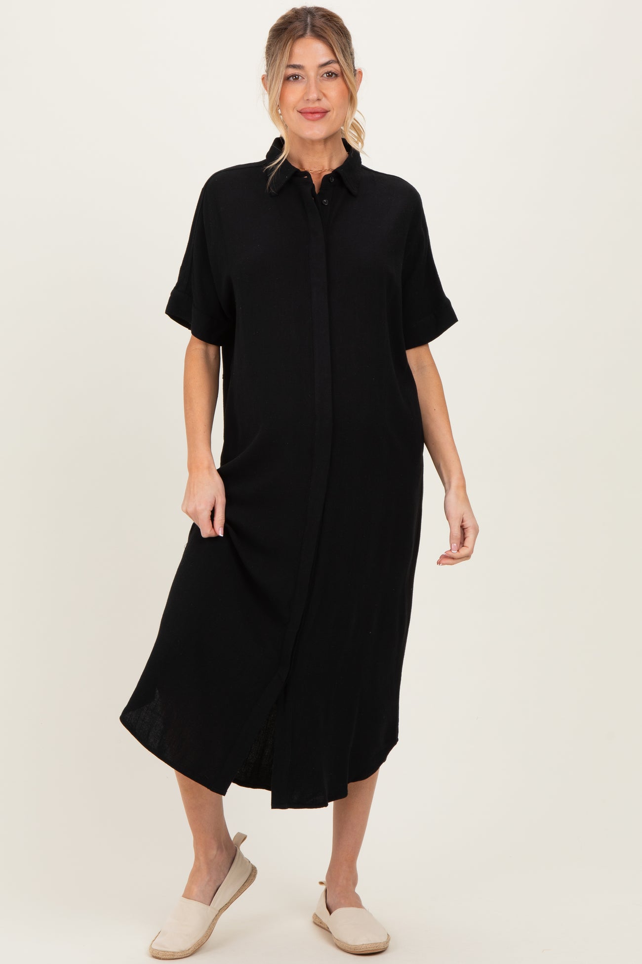 woman wearing a black short sleeve maternity dress with button down front and side slits