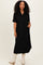 woman wearing a black short sleeve button-up maxi dress with pockets and styled with beige knee-high boots