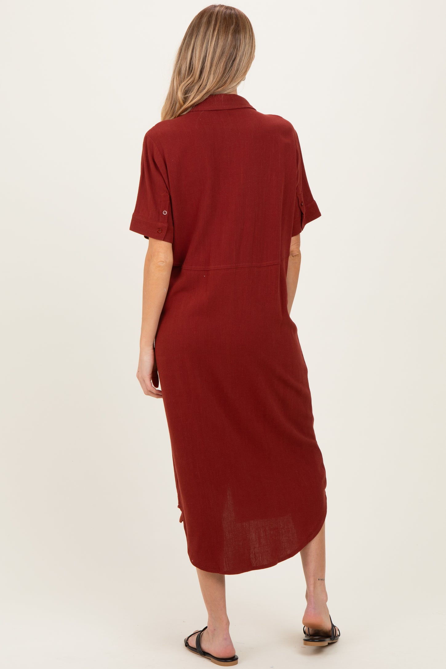 woman wearing a maroon short sleeve maternity dress, view from the back, featuring a relaxed fit and knee-length design