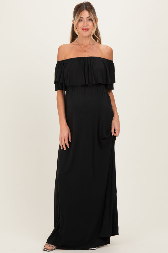 woman wearing a black off-shoulder maternity maxi dress showcasing her baby bump