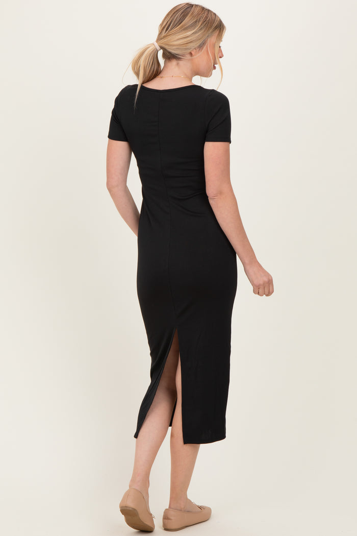 woman wearing a black ribbed midi dress with short sleeves and a back slit, viewed from the back
