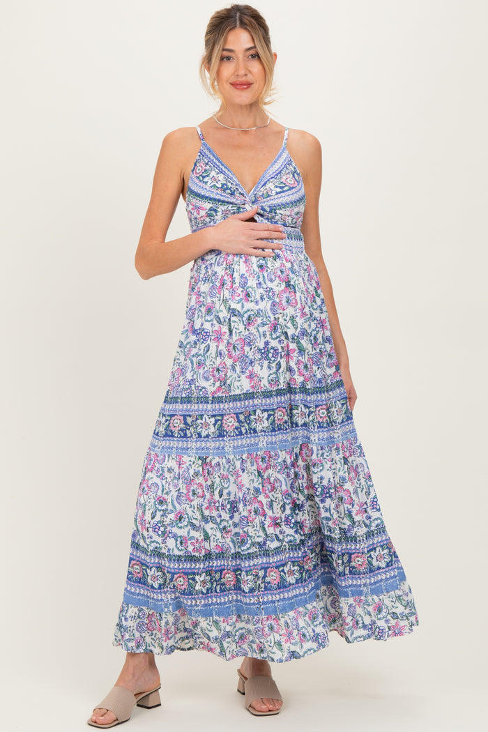 woman wearing a floral print maternity maxi dress and holding her baby bump