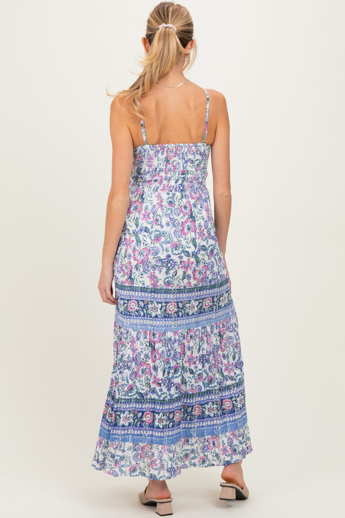 woman wearing a floral print maternity maxi dress with adjustable straps, showcasing a relaxed fit and flowing skirt from the back