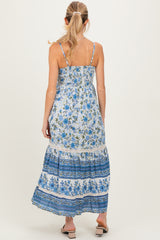 woman wearing a floral maternity maxi dress with blue and white patterns, showing a relaxed fit and adjustable straps