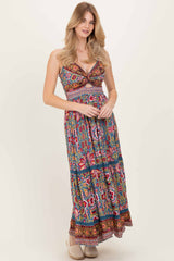 woman wearing a colorful floral maxi dress with a plunging neckline and a tiered skirt