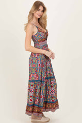 woman wearing a colorful bohemian maxi dress with floral patterns and a fitted bodice, posing sideways