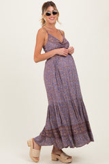 woman wearing a purple patterned maternity maxi dress with spaghetti straps and a visible baby bump