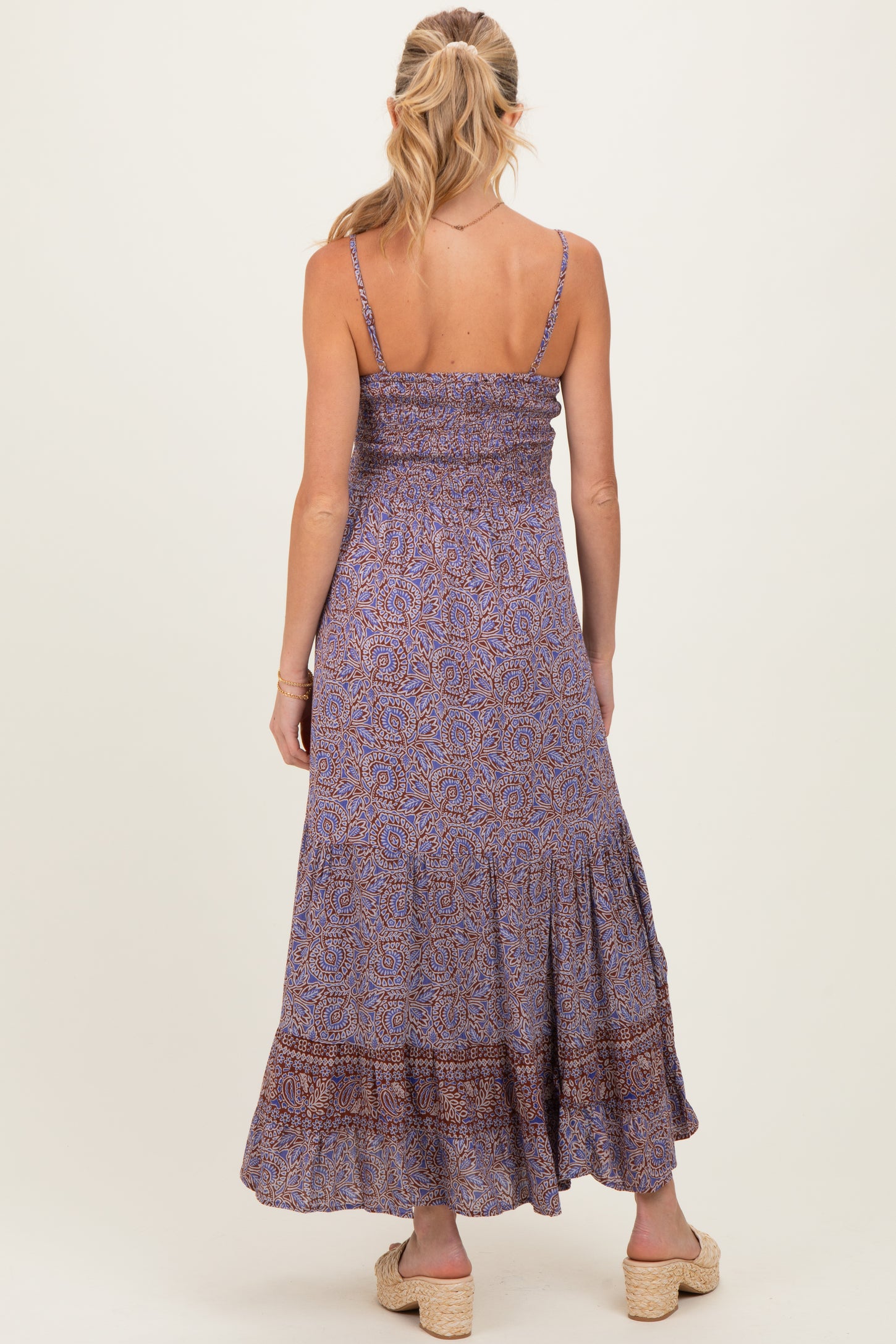 woman wearing a purple floral maternity maxi dress with a smocked bodice and a tiered skirt