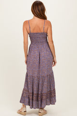 woman wearing a purple patterned maxi dress with smocked bodice and tiered skirt, viewed from the back