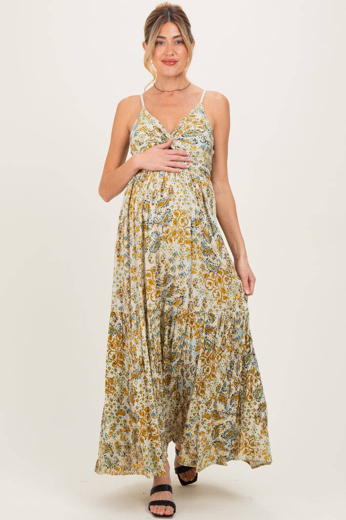 woman wearing a floral print maternity maxi dress with adjustable straps and a visible baby bump
