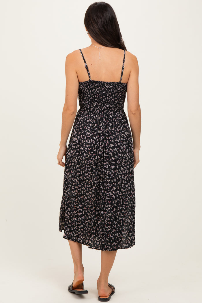 woman wearing a black floral midi dress with adjustable spaghetti straps and a smocked back