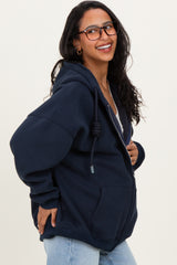 woman wearing a navy blue oversized maternity hoodie with a drawstring and smiling