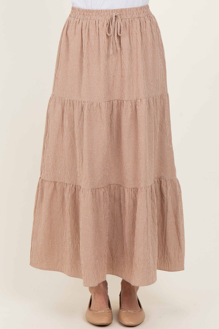 woman wearing a brown and white checked tiered maxi skirt with an elastic waistband and drawstring detail