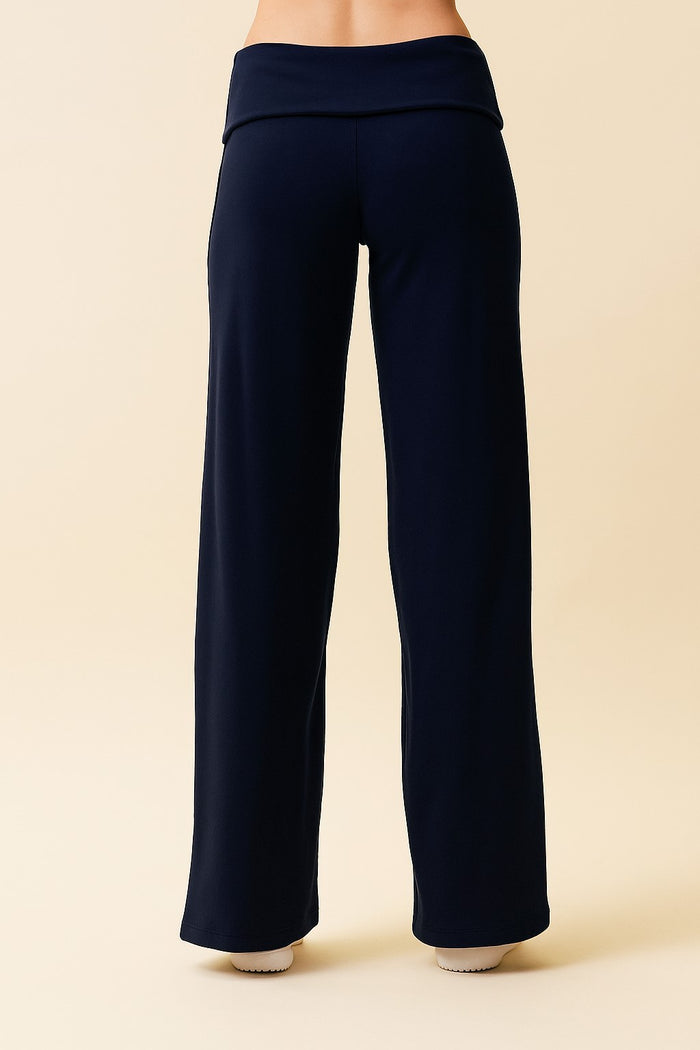 woman wearing navy blue wide-leg yoga pants with a fold-over waistband, viewed from the back