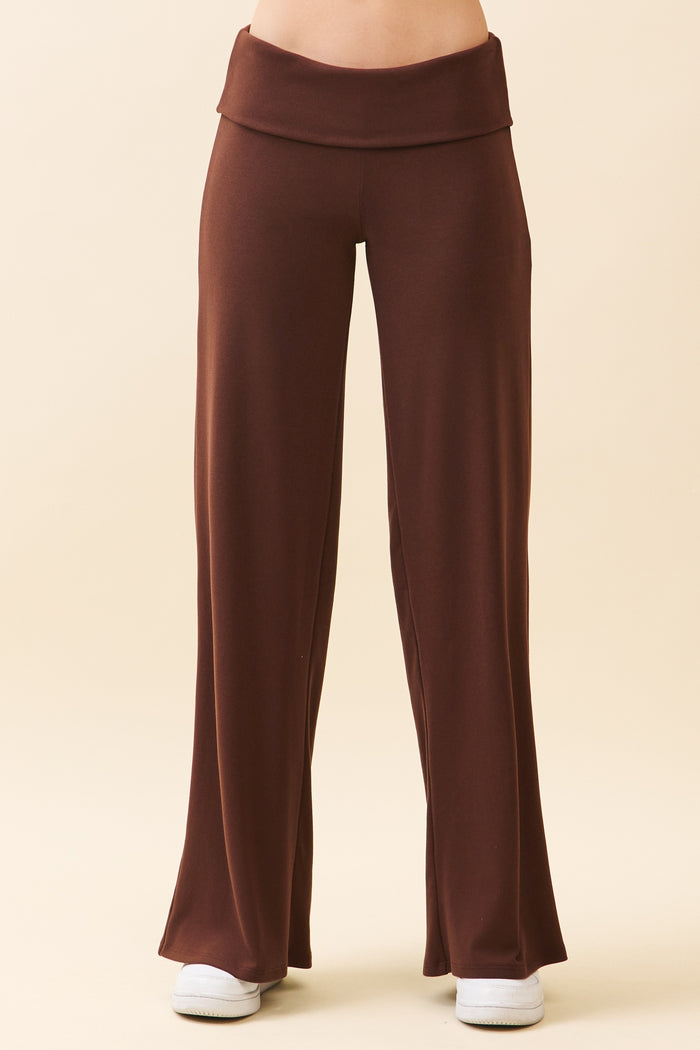 woman wearing brown flared lounge pants with a high waistband and side pockets