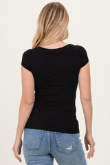 woman wearing a black ribbed short sleeve top with a fitted silhouette and back view, paired with light blue jeans